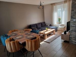 ein Wohnzimmer mit einem Tisch und einem Sofa in der Unterkunft Maison de ville - terrasse sud, a 10 min des plages in Saint-Brieuc