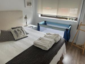a bedroom with a bed with two towels on it at Foz Relógio Apartment in Figueira da Foz