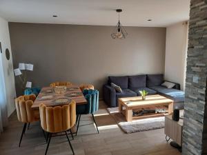 ein Wohnzimmer mit einem Sofa und einem Tisch in der Unterkunft Maison de ville - terrasse sud, a 10 min des plages in Saint-Brieuc