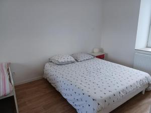 a bedroom with a bed with a white comforter at Maison de ville - terrasse sud, a 10 min des plages in Saint-Brieuc