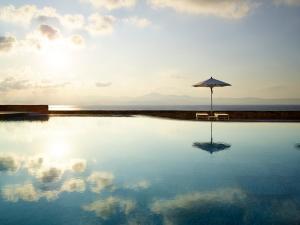 an umbrella sitting in the middle of a swimming pool at Summer Senses Luxury Resort in Logaras