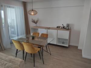 a dining room with a glass table and chairs at Aparthotel Black Sea in Constanţa