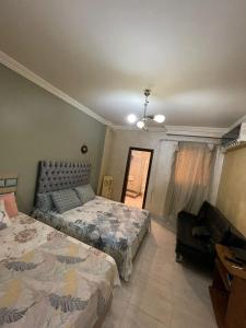a bedroom with two beds and a couch at New Cairo COZY Studio 2 bedrooms & 2 bathrooms in Cairo