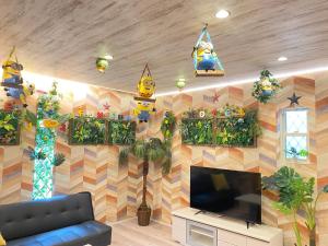 uma sala de estar com televisão e uma parede com decorações em Hotel Jungle fun fun em Osaka