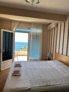 a bedroom with a large bed with a view of the ocean at Nikić Apartments in Ulcinj