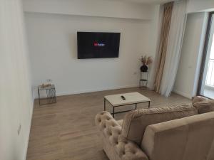 a living room with a couch and a flat screen tv at Aparthotel Black Sea in Constanţa