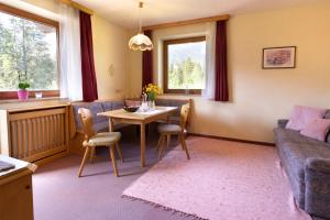 a living room with a table and a couch at Haus Almrose in Leutasch