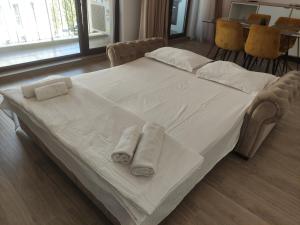 a large white bed with towels on top of it at Aparthotel Black Sea in Constanţa