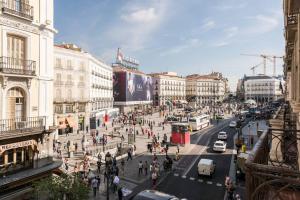 a busy city street with people and buses and cars at Studio 4 Puerta Del Sol in Madrid