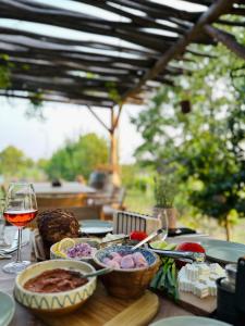 a table with a plate of food and a glass of wine at Perryland Urban Farm in Piatra