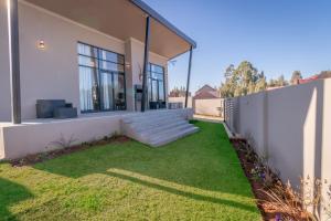 a house with a lawn in front of it at Dorpshuis in Dullstroom