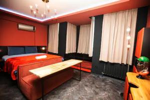 ein rotes Schlafzimmer mit einem Bett, einem Stuhl und einem Sofa in der Unterkunft Black Mansion in Istanbul