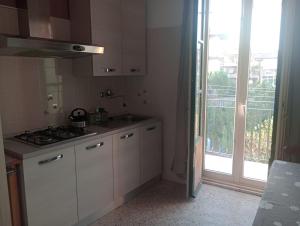 a kitchen with a stove and a sink and a window at A Catania Vicino l'Etna in Tremestieri Etneo