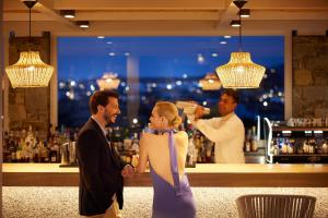 a man and woman standing in front of a bar at Summer Senses Luxury Resort in Logaras