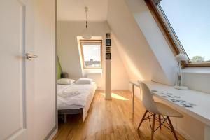 a small attic bedroom with a bed and a desk at Surf&Sail Apartament Gdynia Orłowo, 400m Plaża, free parking in Gdynia