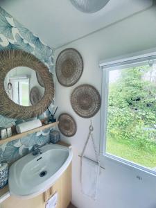 baño con lavabo, espejo y ventana en Domek holenderski Hampton en Dominice