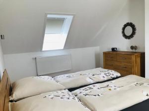 twee bedden in een slaapkamer met een spiegel en een dressoir bij Ferienhaus Kader in Eckernförde