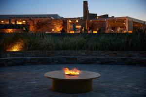 a fire pit in a courtyard with a building in the background at Summer Senses Luxury Resort in Logaras
