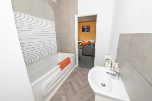 a bathroom with a white tub and a sink at Versatile Cozy & Spacious Comfort Hull Apartments in Hull