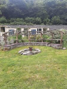 a garden with a stone wall in a yard at Off grid Rosie Sheperd hut and summerhouse plus 1 acre at Tanyrallt in Llanybydder