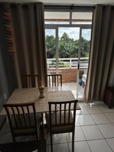 comedor con mesa y sillas y ventana grande en Flat no Condomínio Gran Lençóis-Barreirinhas - MA en Barreirinhas