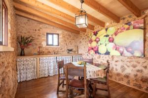 una sala da pranzo con tavolo e un dipinto di frutta di Villa sa teulada a Santa Margalida