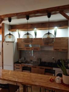 a kitchen with a wooden table and two pendant lights at Wczasy Żywki in Kruklanki