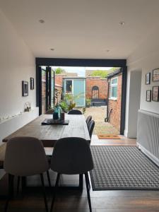 a dining room with a wooden table and chairs at Luxury Spacious Renovated Townhouse in Grantham