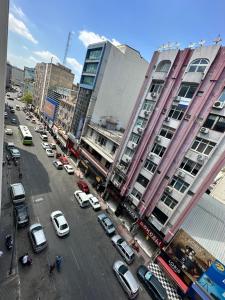 een stadsstraat met auto's geparkeerd voor gebouwen bij GRAND CLOVER otel in Seyhan