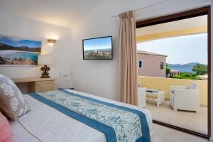 a bedroom with a bed and a large window at Hotel Capriccioli in Porto Cervo