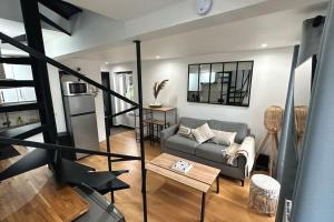 a living room with a couch and a table at Charmant duplex proche Paris in Saint-Maurice +1 photo