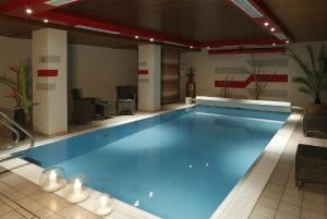 a large swimming pool with blue water in a building at Hotel Restaurant Haus Rebland in Baden-Baden