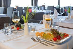 a table with two plates of food and glasses of wine at Hotel Restaurant Haus Rebland in Baden-Baden