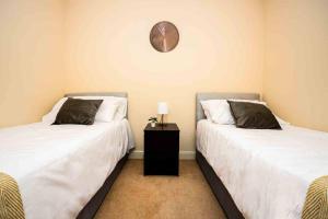 twee bedden naast elkaar in een kamer bij Clarkson Court 1Bedroom Flat in Hatfield