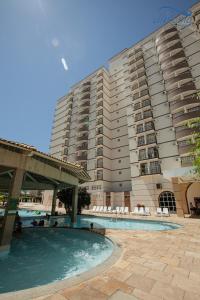 a large building with a swimming pool in front of a building at diRoma Exclusive com um dia no Acqua Park Splash e Slide in Caldas Novas