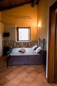 a bedroom with a bed in a room with a window at Agriturismo La Sena in Santa Caterina Dello Ionio Marina