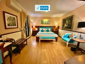 a hotel room with a bed and a couch and chairs at HANZ Hoa Huong Duong Hotel in Ho Chi Minh City
