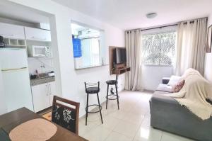 Condomínio Olhos D'agua في مويا: غرفة معيشة مع أريكة ومطبخ