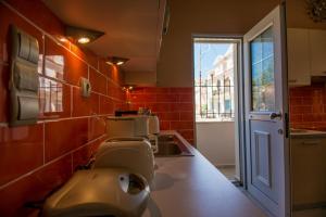 a kitchen with red tiles on the walls at Sofia's Delightful Apartment in Argostoli +69 photos