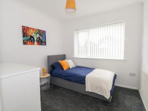a small bedroom with a bed and a window at 28 Wordsworth Avenue in Wigan