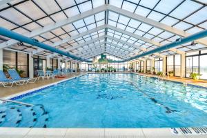 a large swimming pool with a glass ceiling at Luxury Oceanfront Condo/Indoor pool/Massage chair in Ocean City