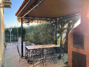 een patio met een tafel en stoelen onder een pergola bij Casa La Vanidosa in Barajas de Melo