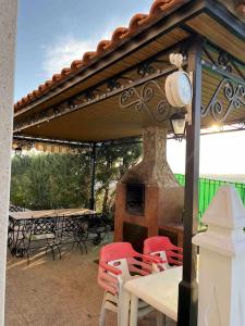 un patio con chimenea, mesas y sillas en Casa La Vanidosa, en Barajas de Melo