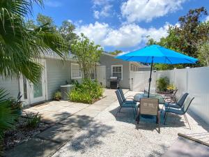 ブレーデントンにあるTropical and Tranquil Bradenton Hideawayのパティオ(椅子、パラソル付きテーブル付)