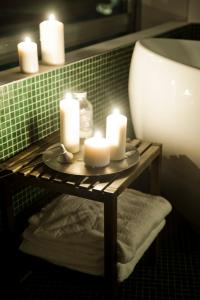 eine Gruppe Kerzen auf einem Regal in einem Badezimmer in der Unterkunft Hotel Daniel Vienna - Smart Luxury Near City Centre in Wien