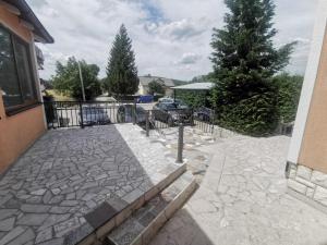 a stone patio with a fence and a tree at Apartman Marija in Livno