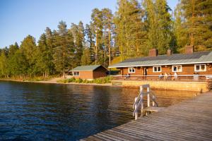 a cabin on the shore of a lake with a dock at Hotel Kiljava in Kiljava