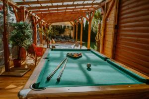 a pool table in a house with cues on it at Morze Domków Wellness & Spa in Dziwnówek