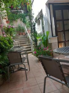 patio ze stołami i krzesłami oraz schody z roślinami w obiekcie Kosta House w Ochrydzie