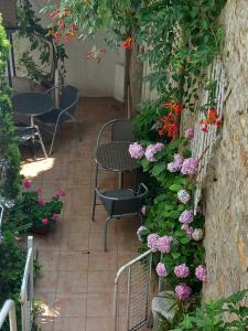 patio ze stołem, krzesłami i kwiatami w obiekcie Kosta House w Ochrydzie